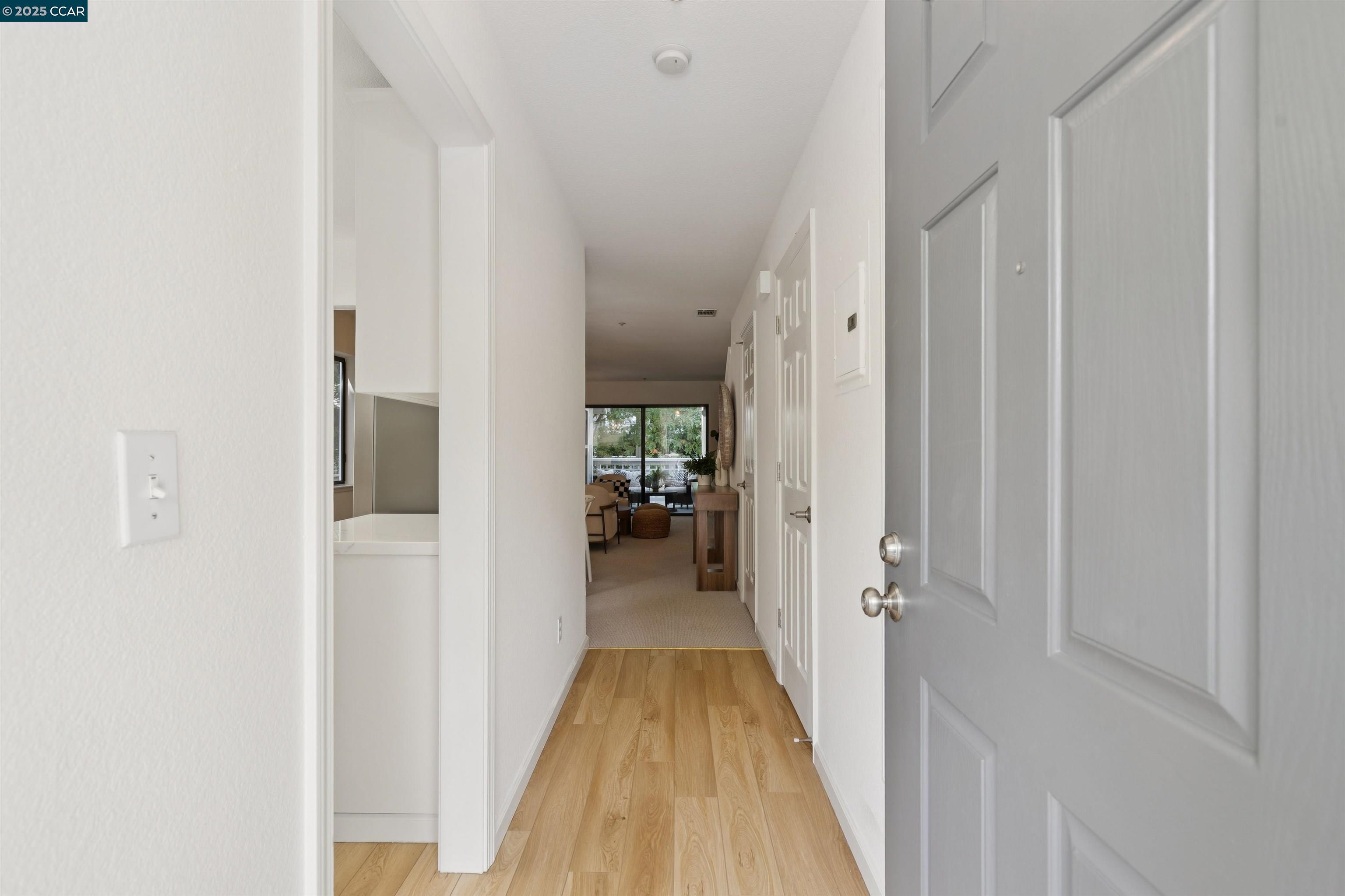 2578 Oak Road, Unit 212 Walnut Creek, CA 94597 - Photo 2 of 27 a view of a hallway with wooden floor and a bathroom