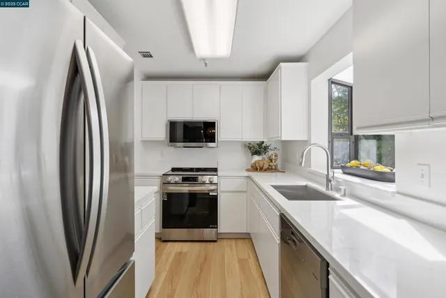 a kitchen with stainless steel appliances a sink stove and refrigerator