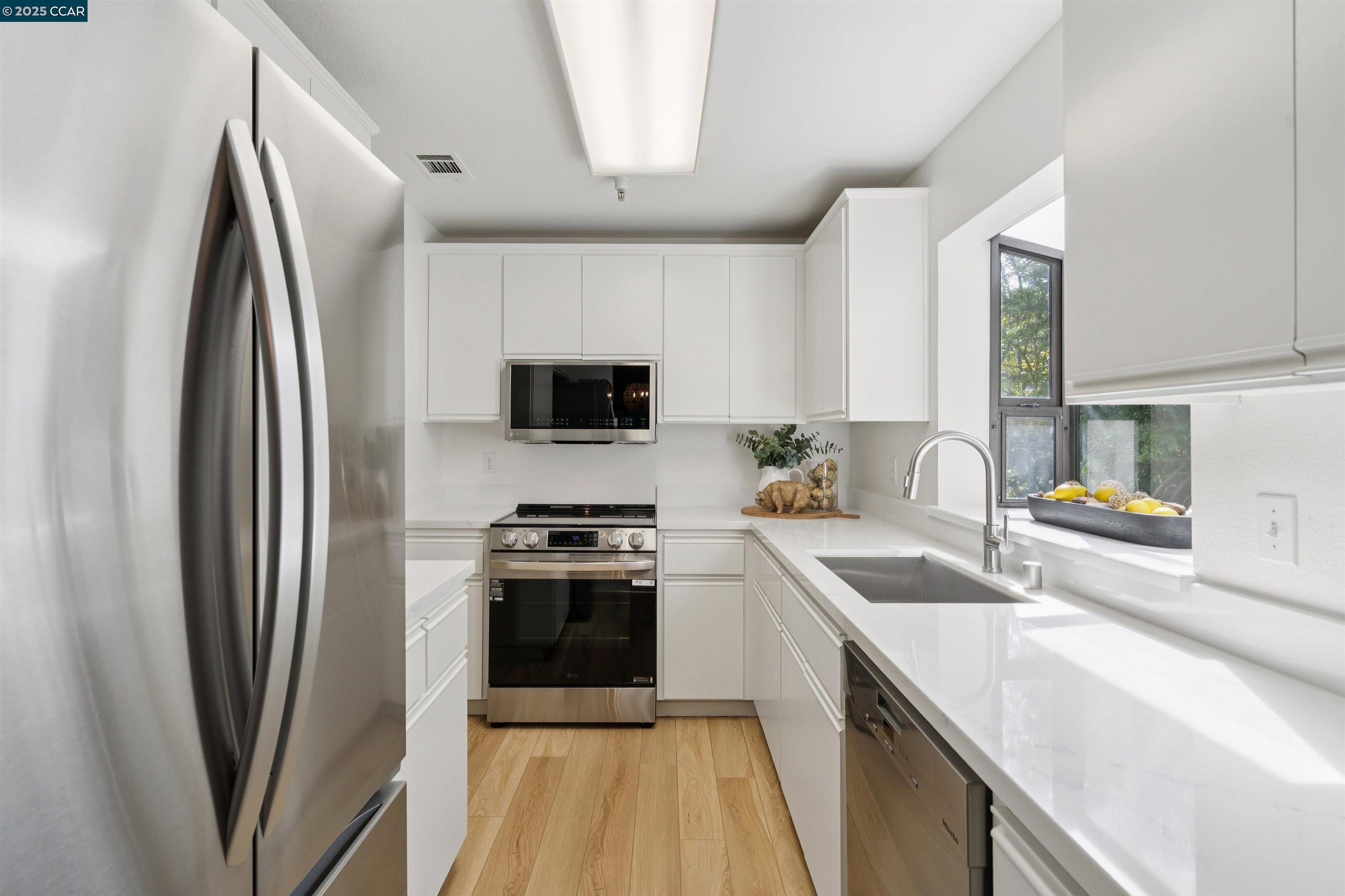 2578 Oak Road, Unit 212 Walnut Creek, CA 94597 - Photo 4 of 27 a kitchen with stainless steel appliances a sink stove and refrigerator