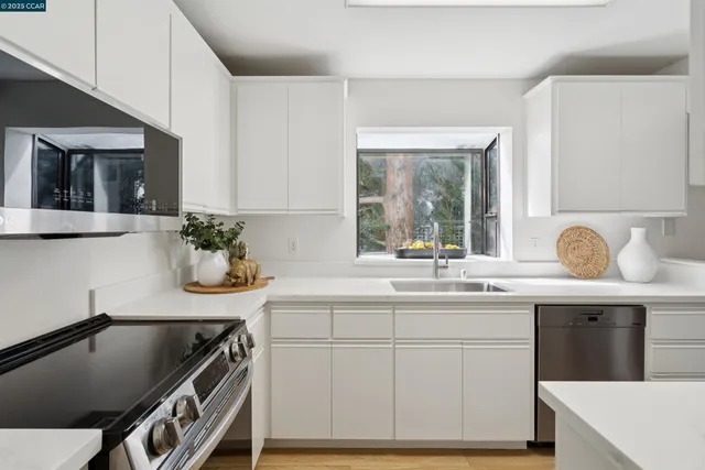a kitchen with a sink a stove and cabinets