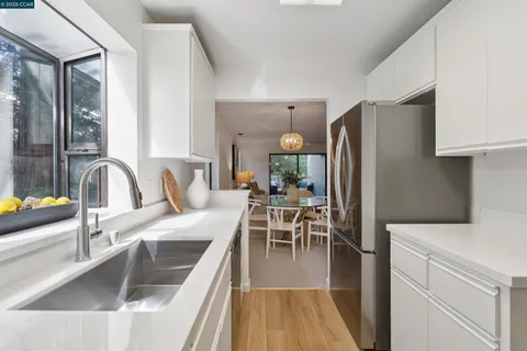 a kitchen with stainless steel appliances granite countertop a sink a stove and a refrigerator