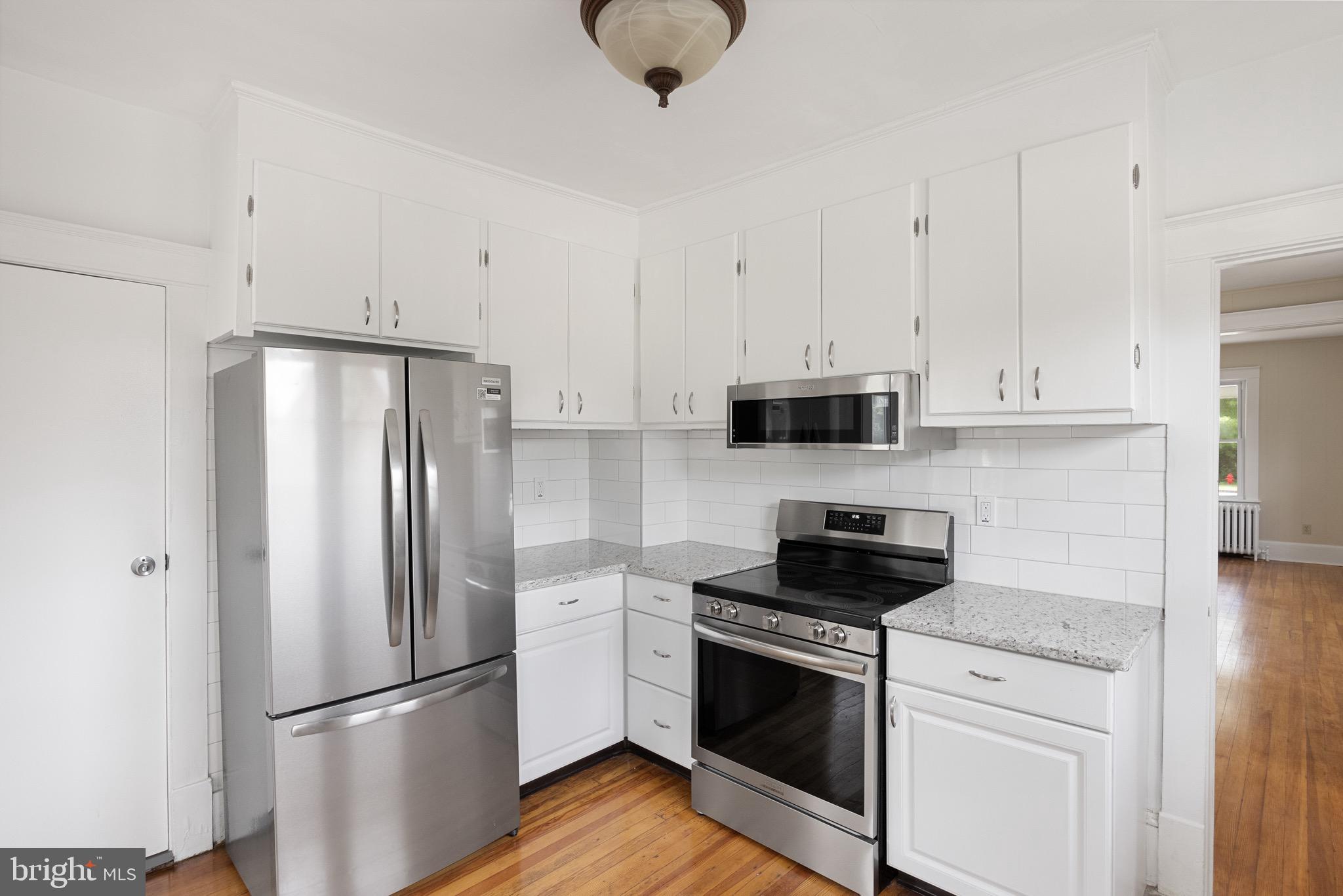 1842 South Spring Road Vineland, NJ 08361 - Photo 14 of 22 a kitchen with stainless steel appliances white cabinets and a wooden floor