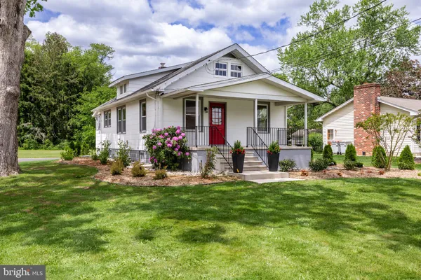 a front view of a house with a yard garden and outdoor seating