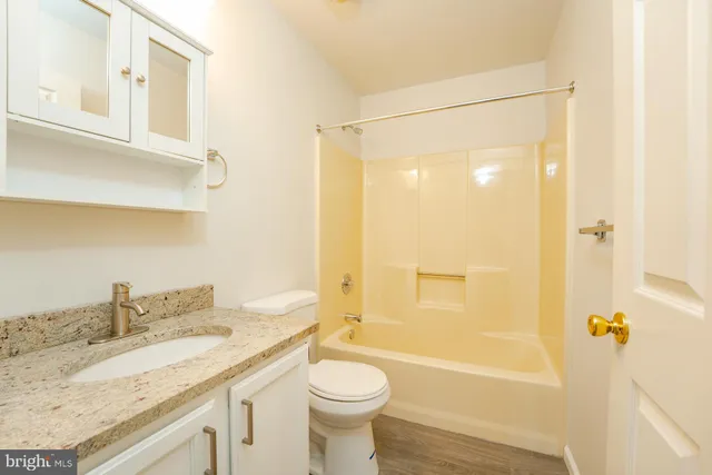 a bathroom with a granite countertop sink toilet and shower