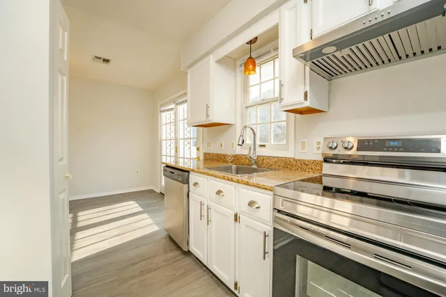 a kitchen with granite countertop a sink and cabinets