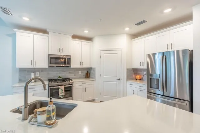 a kitchen with stainless steel appliances a sink stove and cabinets