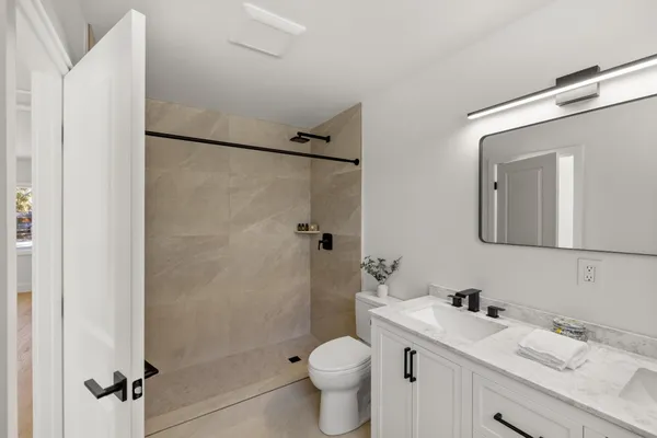 a bathroom with a granite countertop sink toilet and shower