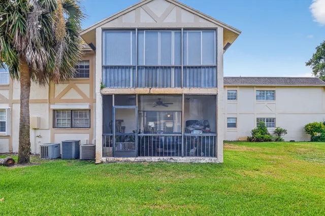 a view of a house with a deck and a yard