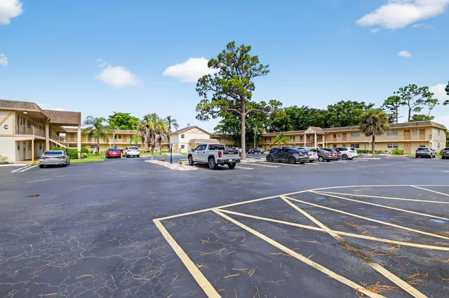 a view of road with card parked on side and retail shops