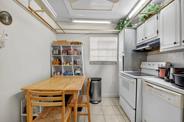 a kitchen with a table chairs a stove and a window