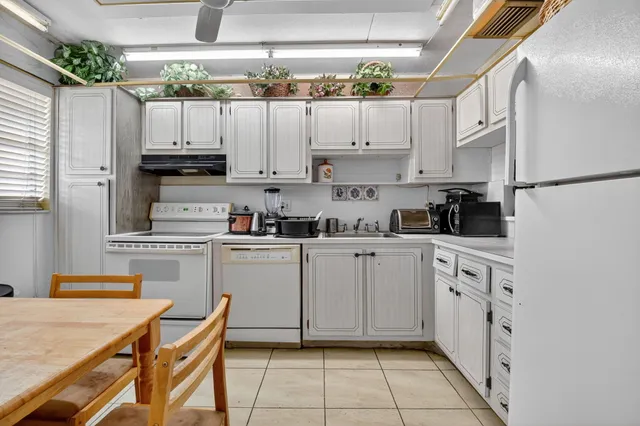a kitchen with cabinets a sink and white appliances