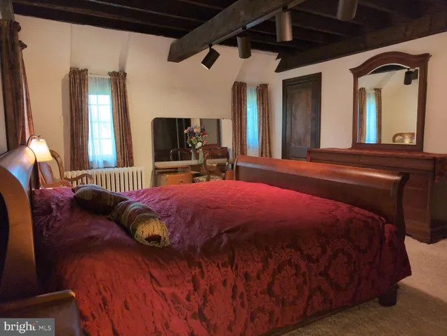 a bed sitting in a bedroom next to a window