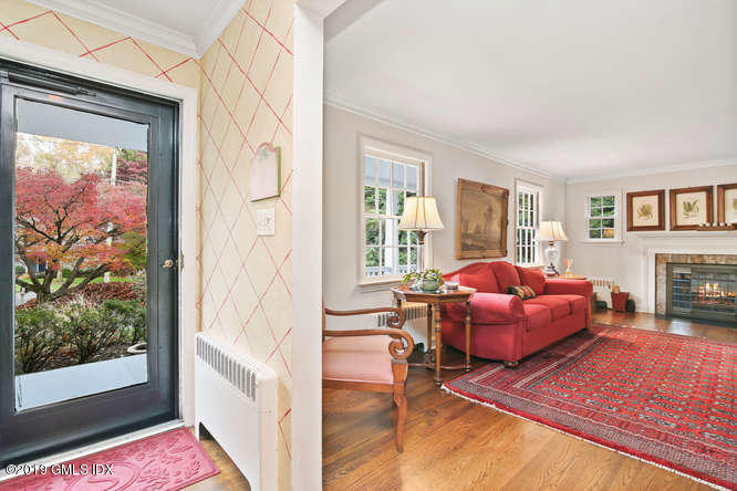 42 Indian Field Road Greenwich, CT 06830 - Photo 5 of 43 a living room with a couch floor to ceiling window and a flat screen tv