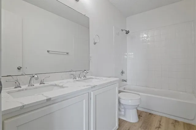 a bathroom with a granite countertop sink a toilet and shower