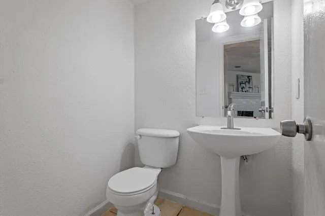 a bathroom with a toilet a sink and mirror