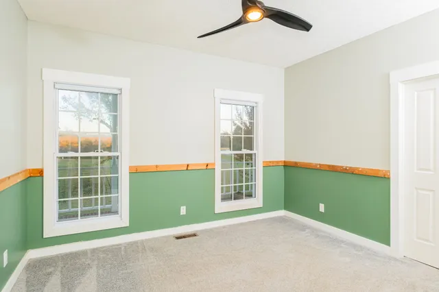 a view of a room with wooden floor and a ceiling fan