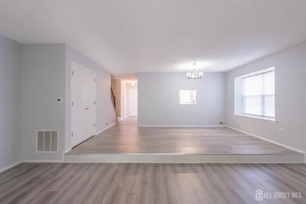 an empty room with wooden floor and window