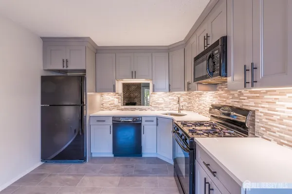 a kitchen with kitchen island granite countertop a sink stove and refrigerator