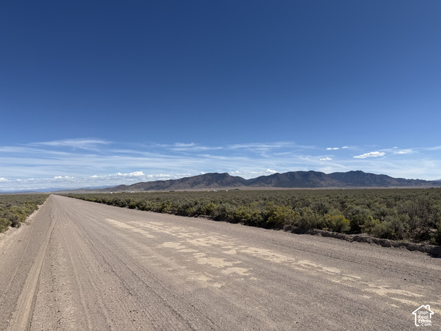 350 West Antelope Springs Road Beryl, UT 84714 - Photo 7 of 14 Expansive desert landscape featuring a dirt road, low-lying natural vegetation, and distant mountain ranges