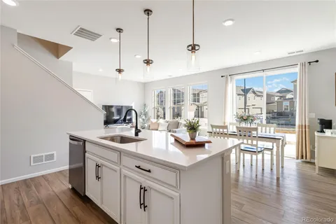 a view of a kitchen and living room with wooden floor