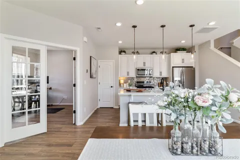 a kitchen with stainless steel appliances granite countertop a refrigerator a stove a sink cabinets and wooden floor