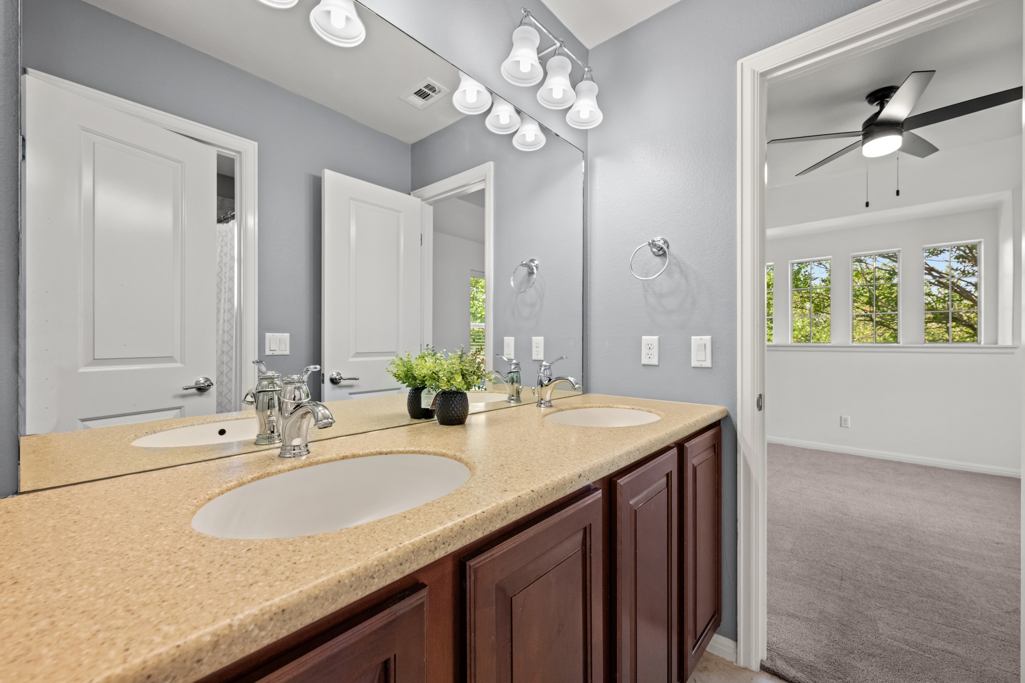 1023 Grassy Field Road Austin, TX 78737 - Photo 31 of 40 Double vanity featuring integrated sinks, a speckled countertop, and dark wood cabinetry