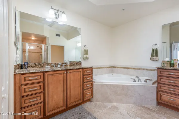 a bathroom with a bathtub a double vanity sink and a large mirror