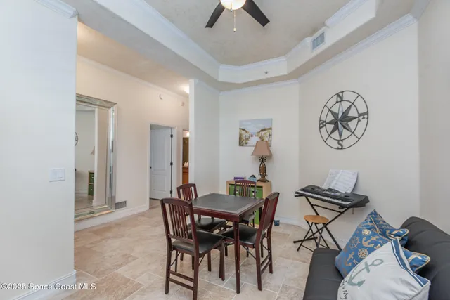 a view of a dining room with furniture and a chandelier fan