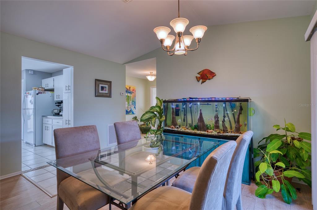 76 Sandstone Circle Venice, FL 34293 - Photo 4 of 37 a view of a dining room with furniture a potted plant and wooden floor