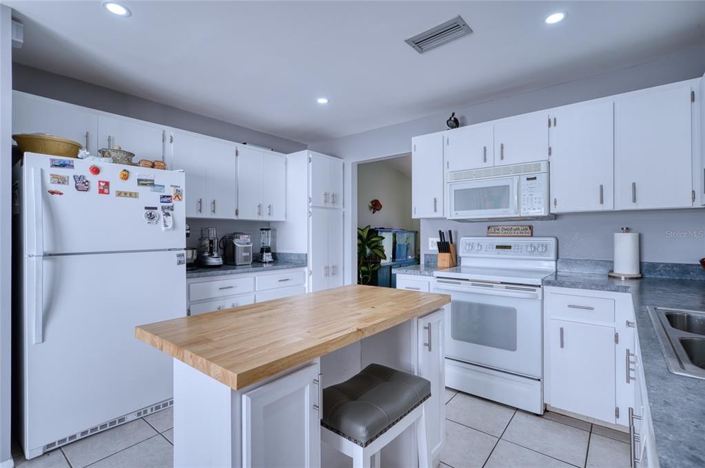 76 Sandstone Circle Venice, FL 34293 - Photo 6 of 37 a kitchen with kitchen island a white counter top space cabinets and stainless steel appliances