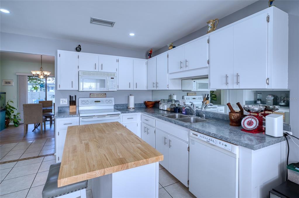 76 Sandstone Circle Venice, FL 34293 - Photo 7 of 37 a kitchen with stainless steel appliances granite countertop a sink dishwasher a stove and white cabinets