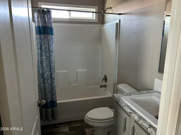 a bathroom with a shower a toilet and a sink