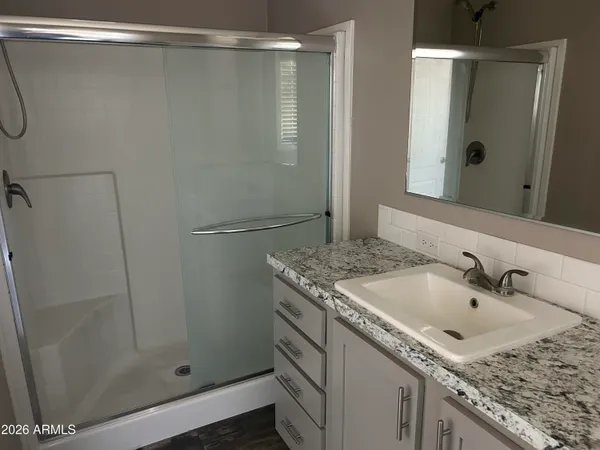 a bathroom with a granite countertop sink and shower