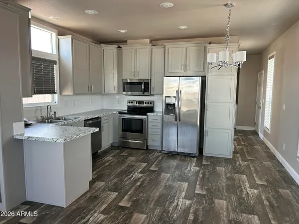 a kitchen with granite countertop a refrigerator a sink a stove a microwave and island