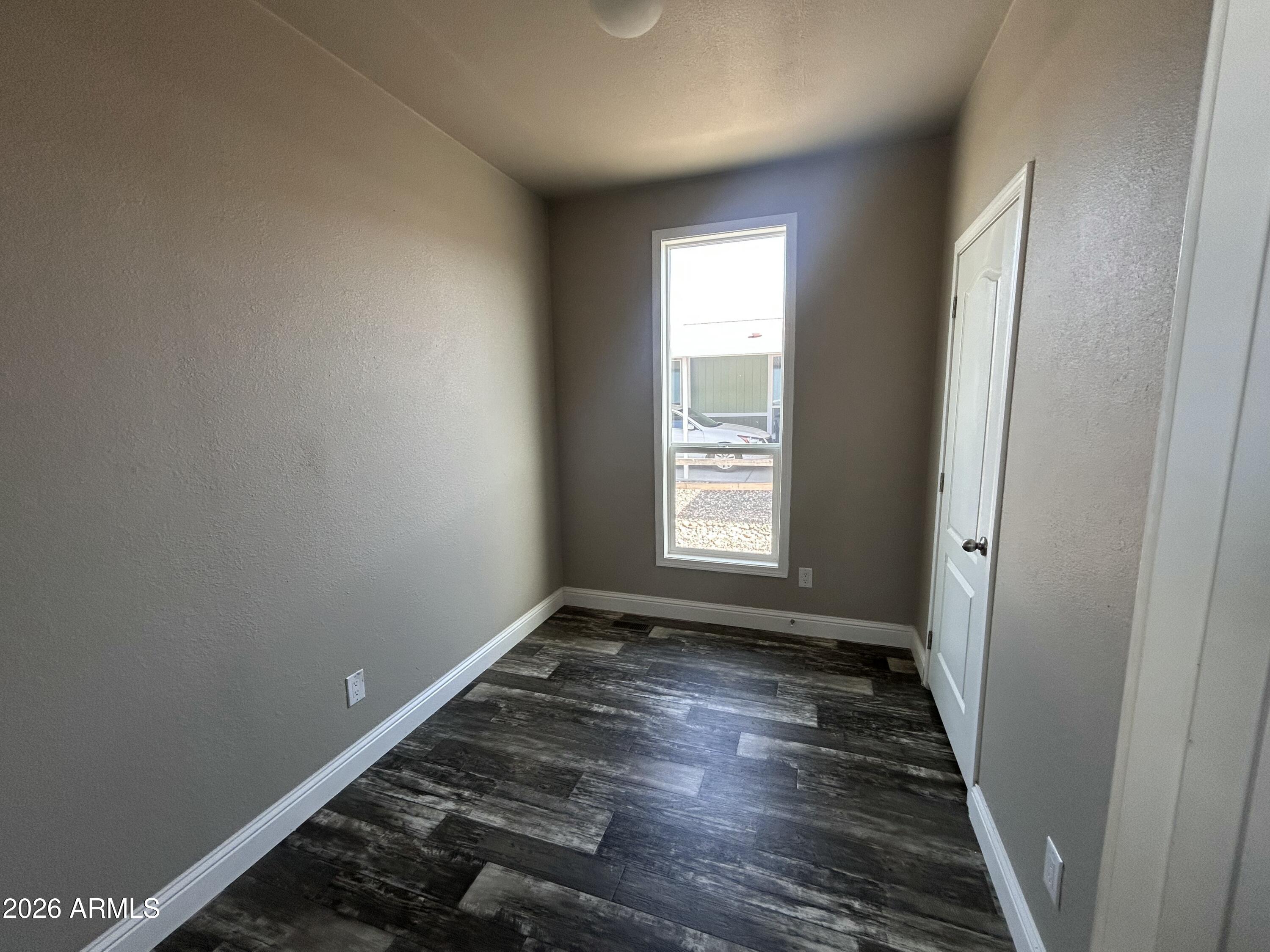 1067 Thorton Road Camp Verde, AZ 86322 - Photo 10 of 21 an empty room with wooden floor and windows