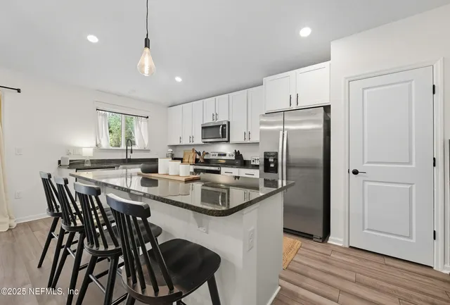 a kitchen with refrigerator cabinets dining table and chairs