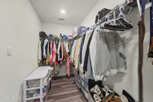 a view of walk in closet with clothes
