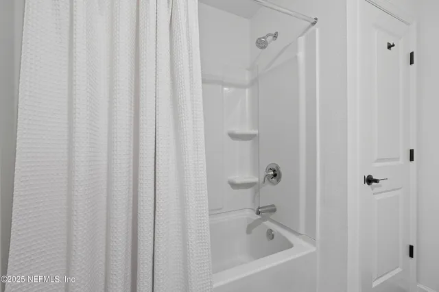 a white bath tub with a shower curtain