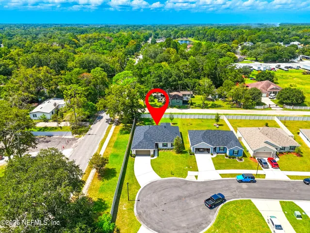 an aerial view of a swimming pool with a yard and seating area