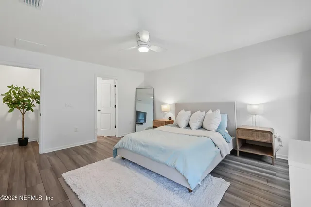 a bedroom with a bed and a potted plant