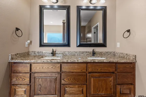 a bathroom with a granite countertop toilet sink and mirror
