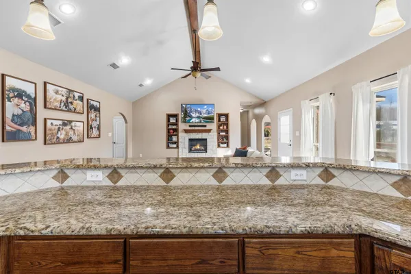 a spacious bedroom with a large bed chandelier and a window