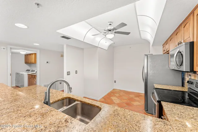 a kitchen with stainless steel appliances granite countertop a stove a sink and a refrigerator