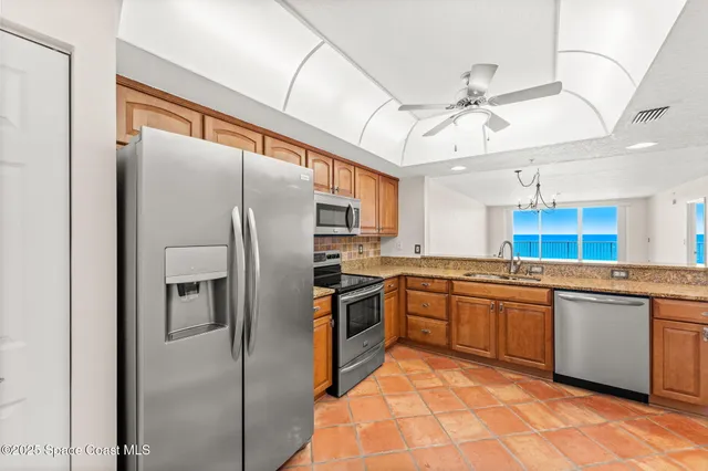 a kitchen with stainless steel appliances granite countertop a refrigerator a stove a sink and dishwasher