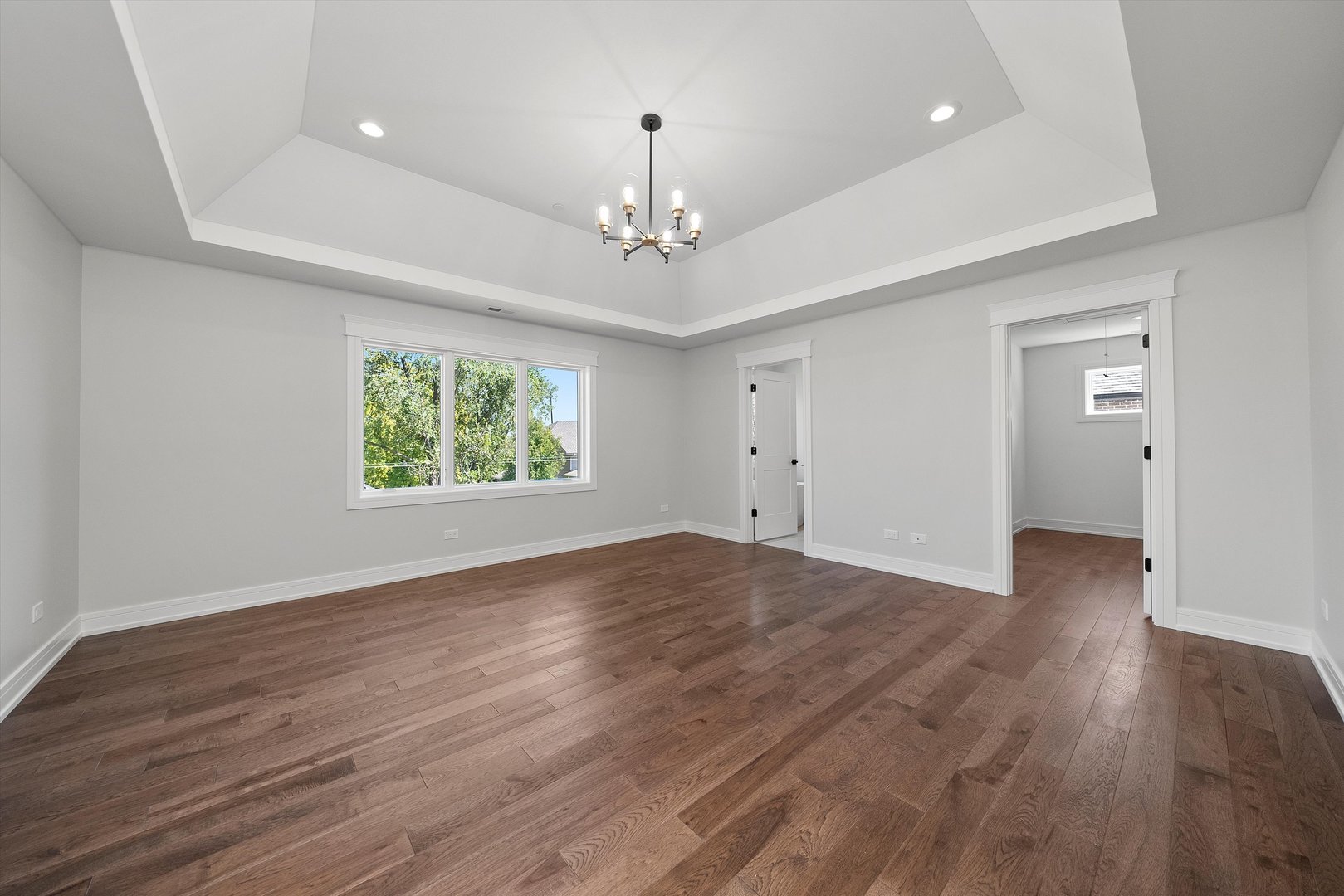 10441 South 83rd Avenue Palos Hills, IL 60465 - Photo 33 of 47 an empty room with wooden floor chandelier and windows