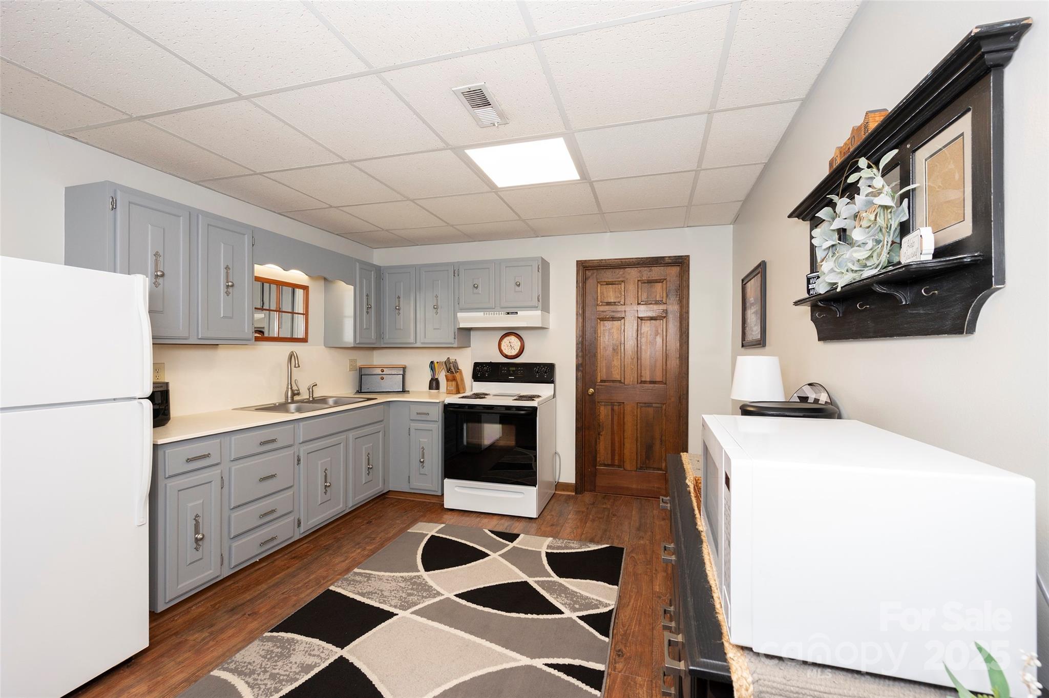 1120 Fred Merritt Road King, NC 27021 - Photo 35 of 45 a kitchen with stainless steel appliances a refrigerator sink and white cabinets