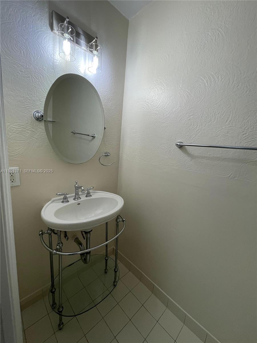 12708 Southwest 49th Drive Miramar, FL 33027 - Photo 12 of 16 a bathroom with a sink a lamp and a mirror