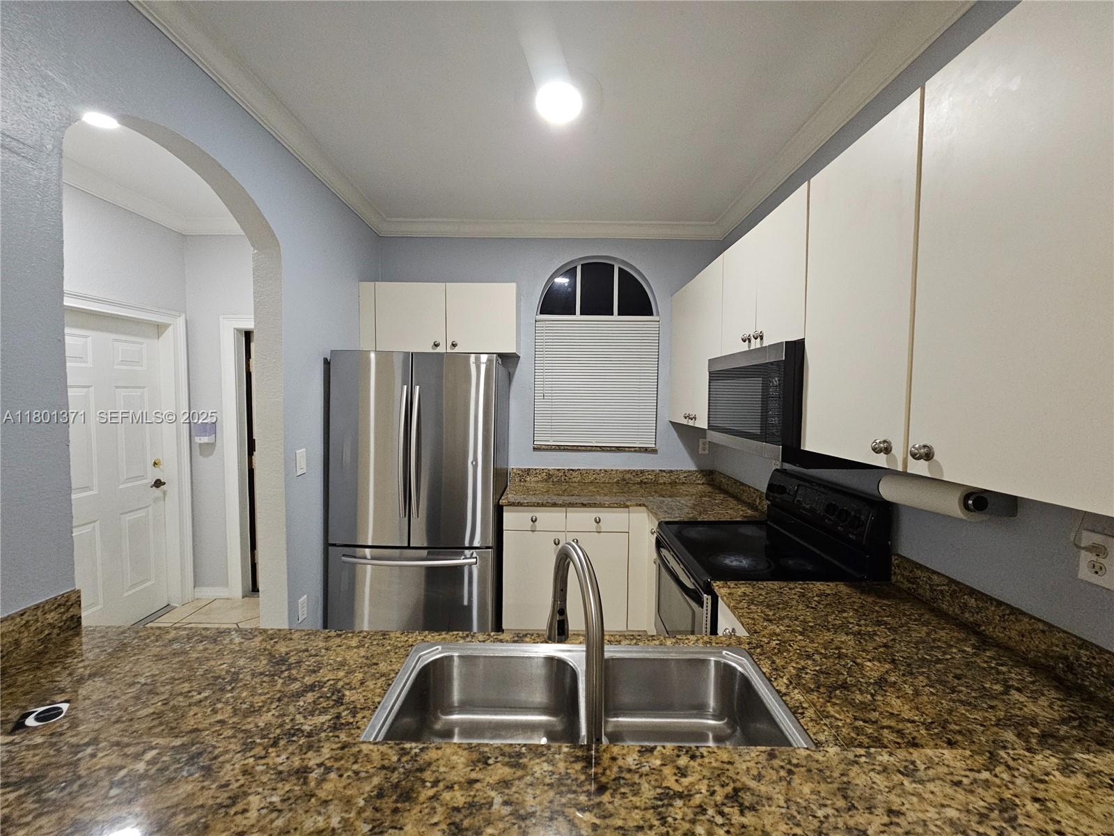 12708 Southwest 49th Drive Miramar, FL 33027 - Photo 10 of 16 a kitchen with kitchen island granite countertop a refrigerator and a sink