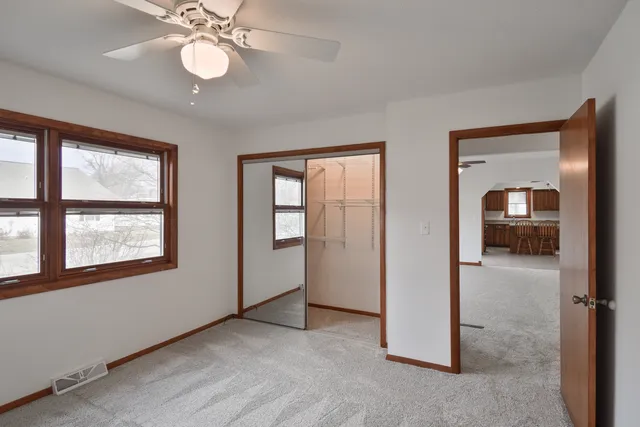 an empty room that has a window and kitchen view