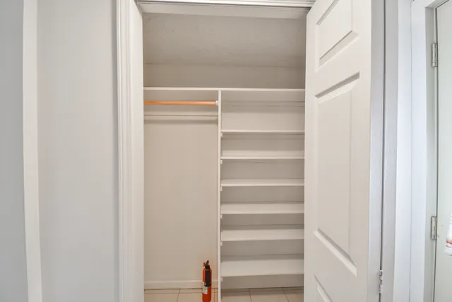 a view of walk in closet with empty racks
